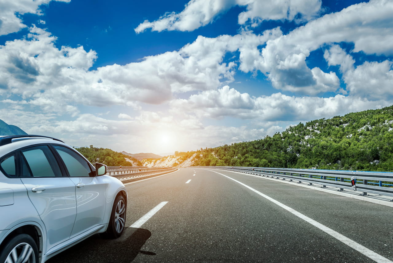 太陽の光をあびて車が走っている様子