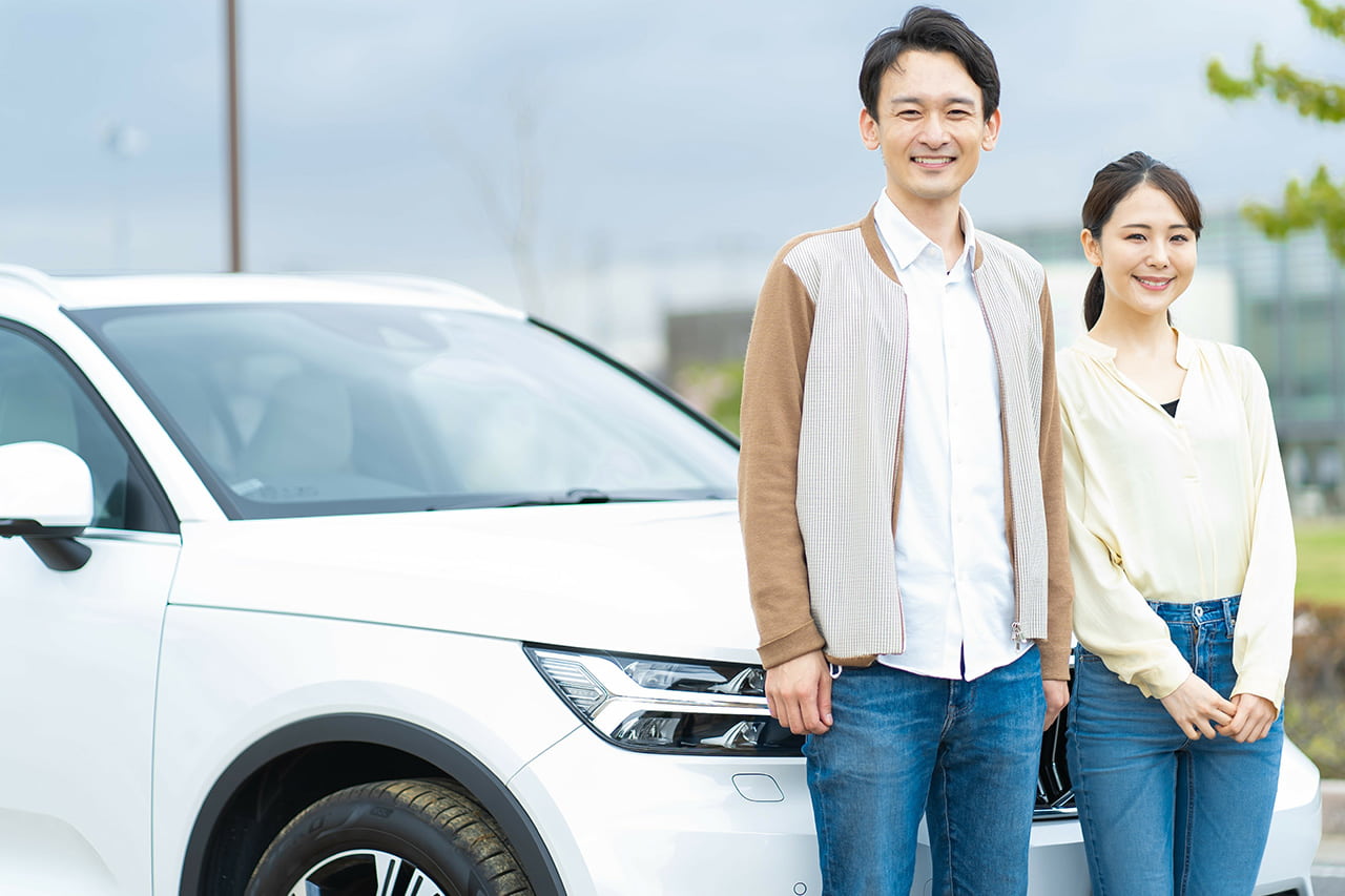 車の前で笑顔の2人